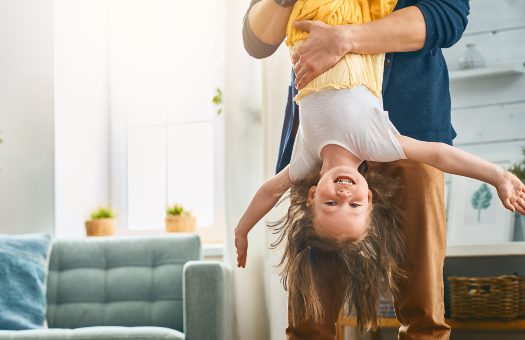 kid laughing while being held upside down